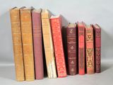 several old books are lined up on a white surface
