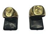 pair of gold plated men ' s and women ' s rings on black leather