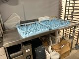une grande table en acier inoxydable sur laquelle sont posés plusieurs verres