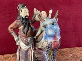 deux figurines représentant un homme et une femme assis sur un cheval