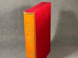 an orange and yellow book sitting on top of a gray surface