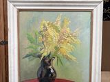une peinture de fleurs dans un vase sur un chevalet