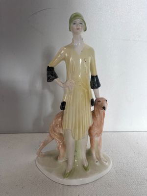 une figurine représentant une femme accompagnée de deux chiens