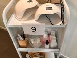 a white cart with a nail dryer and other items on top of it