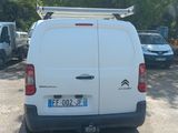 a white van parked in a parking lot with trees in the background