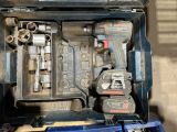 une boîte à outils contenant des outils, posée sur le sol
