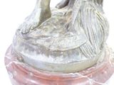 a statue of a woman sitting on top of a marble base