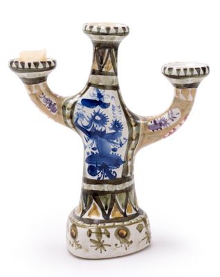 a blue and white vase with two candles on it