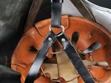 a helmet with a leather strap hanging from it ' s side