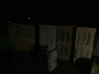 des toilettes dans le noir, à côté d'une pile de cartons