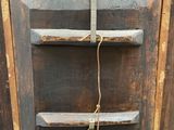 an old wooden cabinet with a rope hanging from it