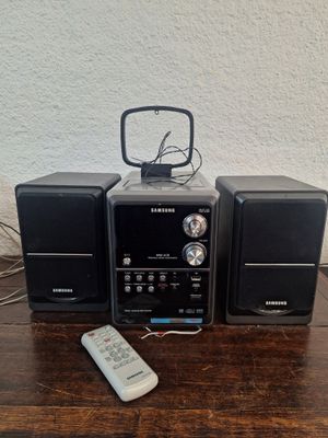 trois haut-parleurs et une télécommande posés sur une table