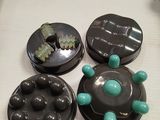 four chocolate covered donuts sitting on a table