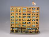 a yellow and blue building with a bird on top of it