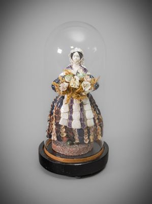 figurine représentant une femme en robe, sous une cloche en verre