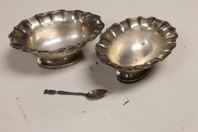 pair of silverplated bowls and spoons on a white surface