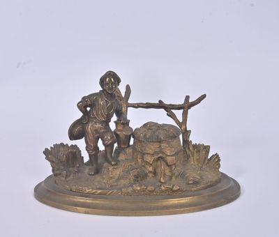 figurine en bronze représentant un homme assis sur un rocher avec un chien