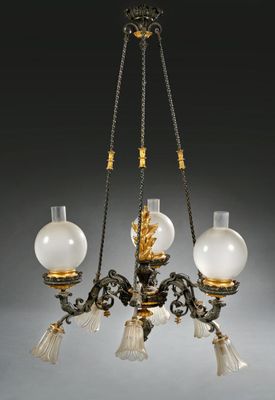 un lustre ancien composé de trois lampes en verre suspendues au plafond