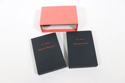trois livres dans un coffret rouge et noir posé sur une surface blanche