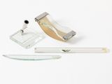 un objet en verre et en métal posé sur une surface blanche