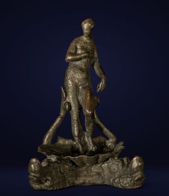 une statue en bronze représentant un homme debout au sommet d'un rocher