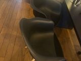 two black chairs sitting next to each other on a wooden floor
