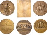 six bronze medals of various types and sizes on a white background