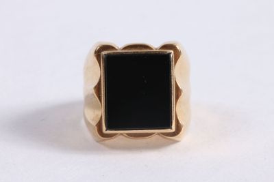 a close up of a gold ring with a black stone in it