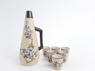 four cups and a pitcher sitting next to each other