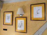 three framed pictures on the wall above a toilet