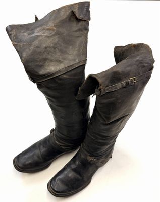 pair of black leather boots on a white surface with a white background