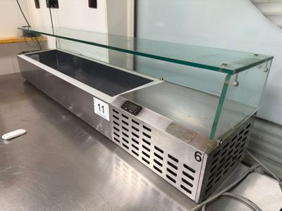 un plan de travail en acier inoxydable surmonté d'une vitrine en verre