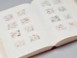 an open book with drawings on it on a table