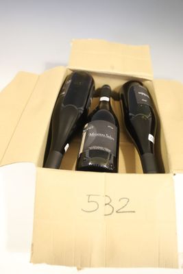 three bottles of wine in a cardboard box on a table