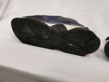 a pair of shoes sitting on a bed next to a pair of shoes