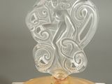 a glass sculpture of a woman on top of a yellow plate
