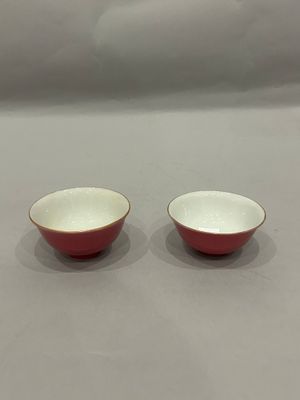 two red and white bowls sitting on top of a table