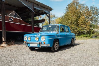 une voiture bleue garée devant un bateau