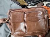 a brown bag sitting on top of a pile of luggage