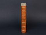 an old book sitting on top of a table next to a black background