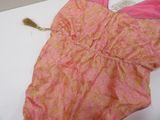 a pink dress with a tassel on it on a table