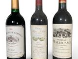 trois bouteilles de vin sont alignées sur une surface blanche