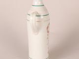 a small white vase with a handle on a table