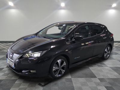 the black nissan leaf is parked in a large room