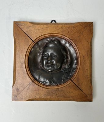 une photo d'une plaque en bronze représentant le visage d'un homme