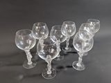 several empty wine glasses are lined up on a black surface