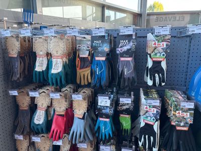 several pairs of gardening gloves are on display in a store