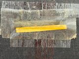 a piece of wax taped to a piece of wood