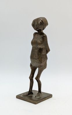 bronze statue of a woman standing on a base with a hat on her head
