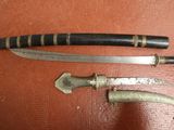 two knives and a knife holder on a table